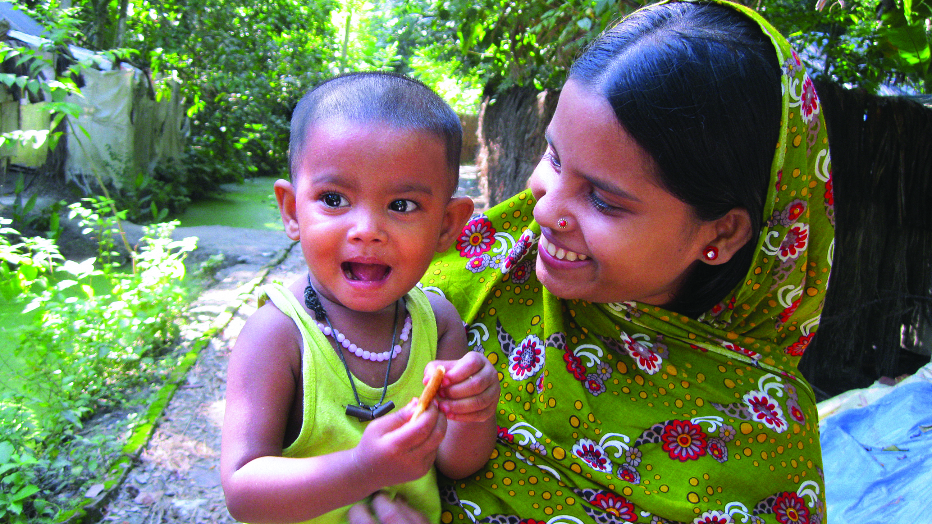 Mother holding child in a green landscape